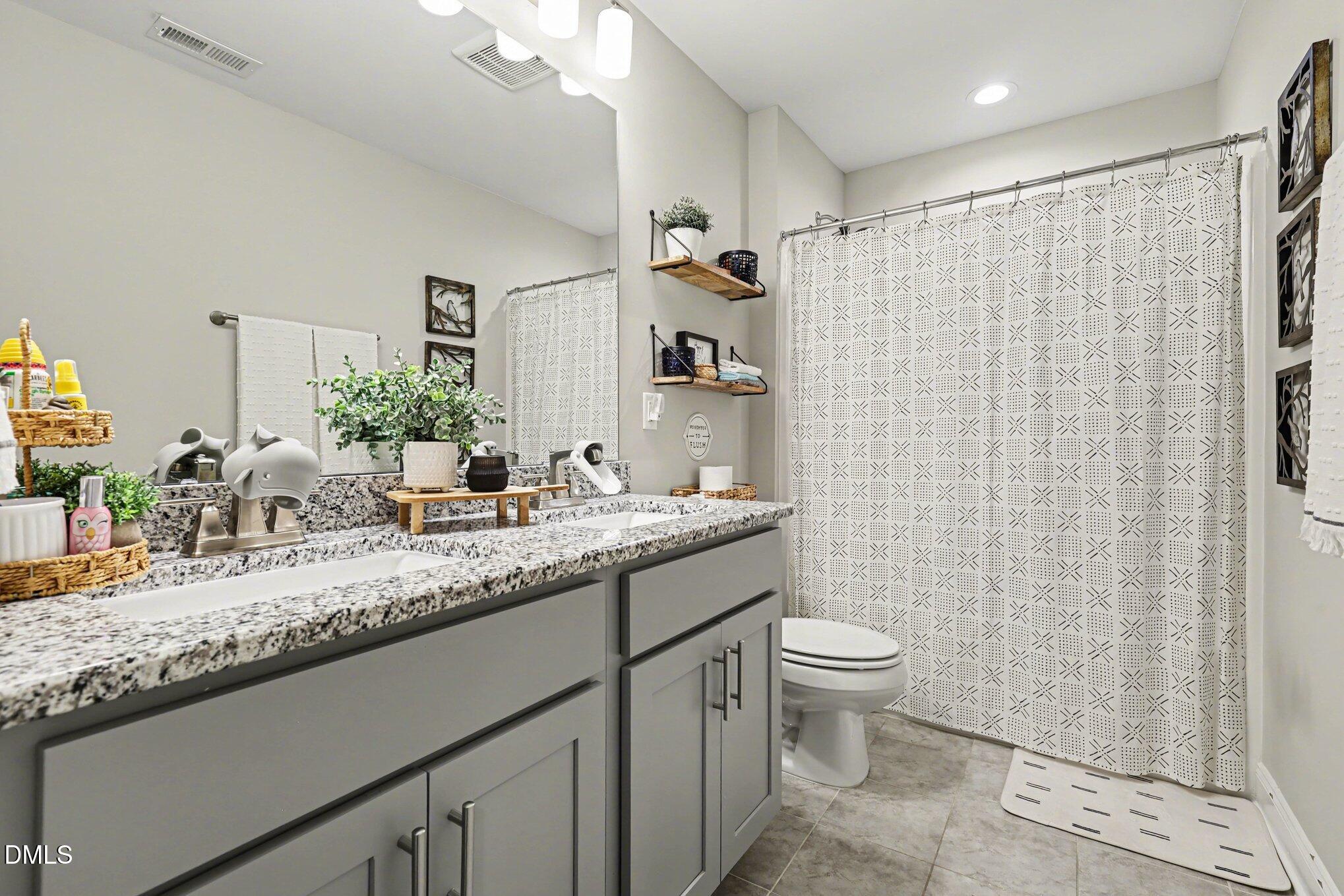 274 Colson Ridge Drive Clayton, NC 27520 - Photo 40 of 48 a bathroom with a granite countertop sink a toilet and a mirror