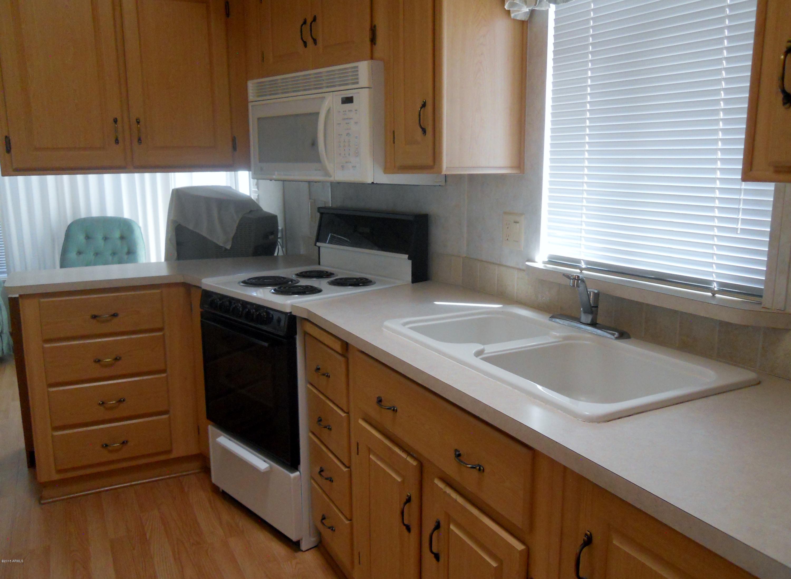 17200 West Bell Road, Unit 798 Surprise, AZ 85374 - Photo 2 of 4 a kitchen with granite countertop a sink a stove and cabinets