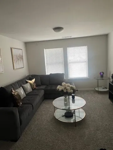 a living room with furniture and a chandelier