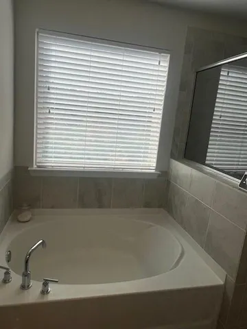 a bath tub sitting in a bathroom next to a window