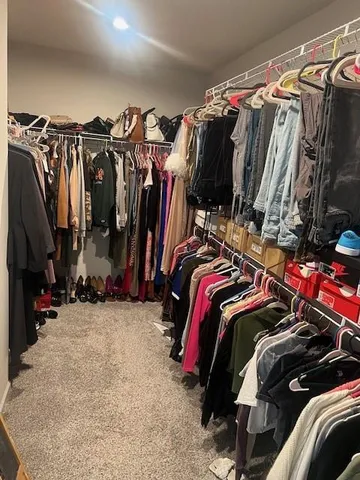 a view of walk in closet with clothes and shoes