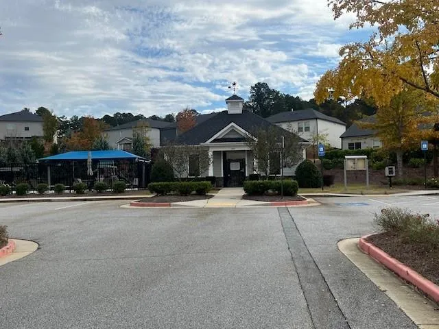a front view of a house with a yard and car parked