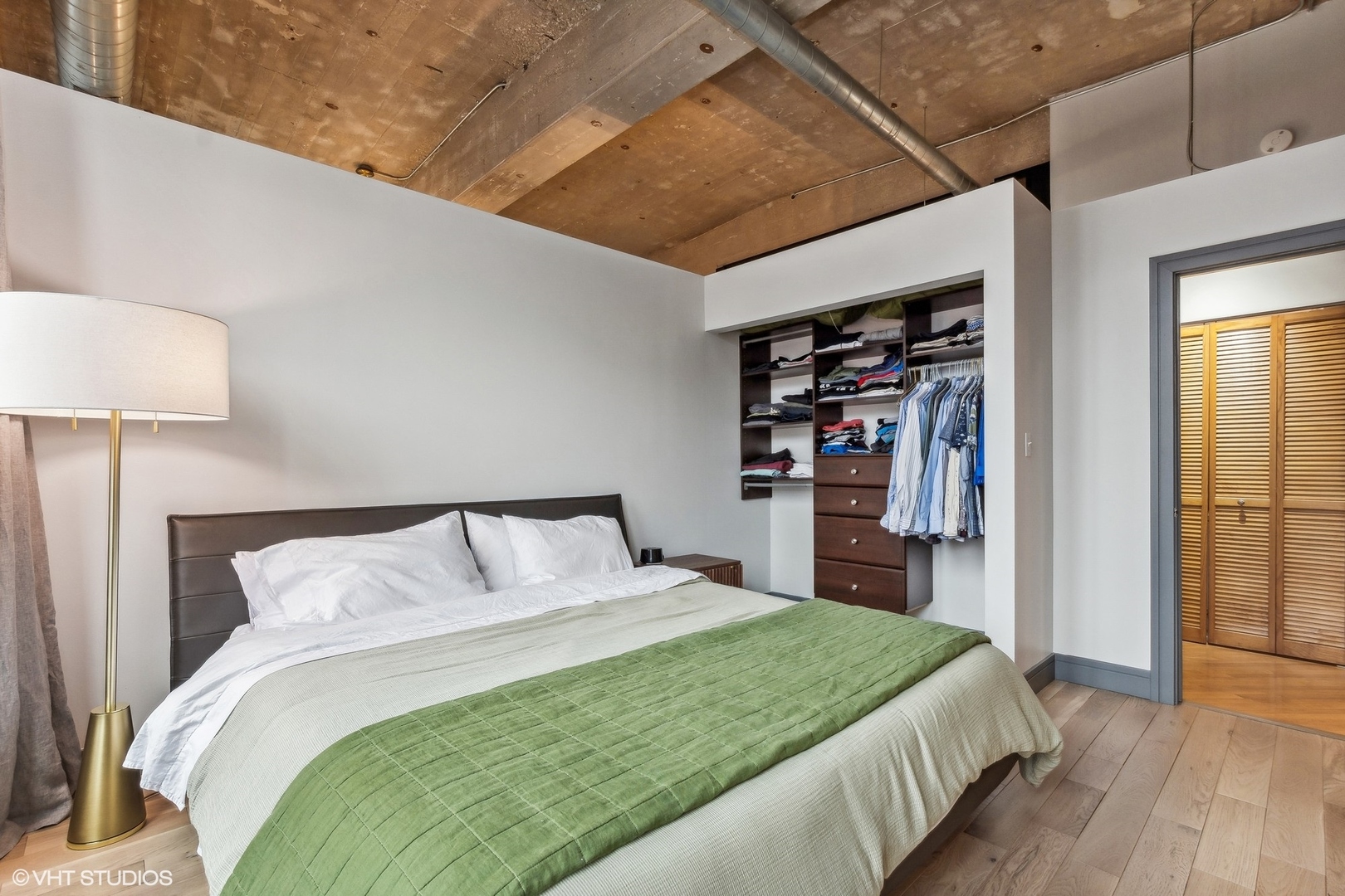 215 North Aberdeen Street, Unit 405A Chicago, IL 60607 - Photo 13 of 20 a bedroom with a large bed and a book shelf