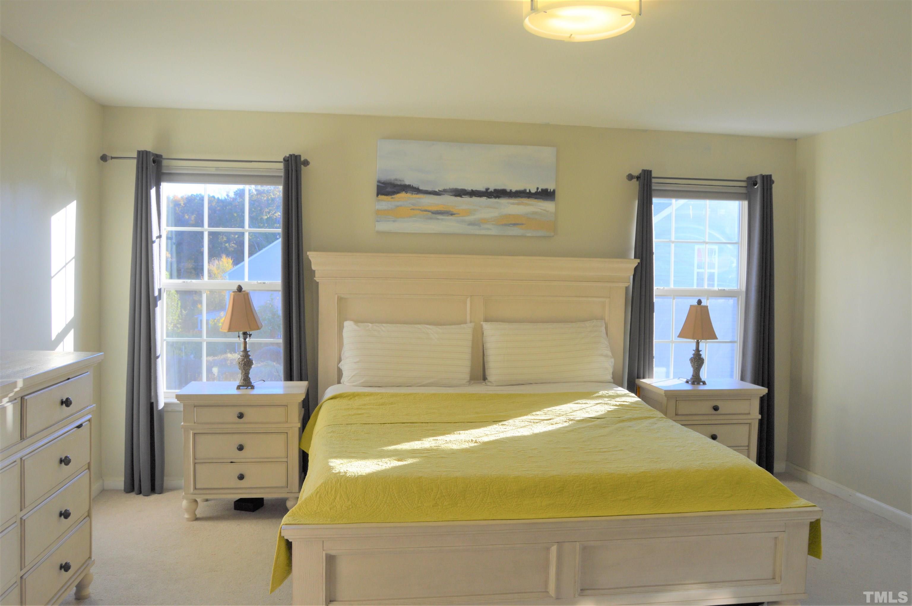 1308 Lombar Street Raleigh, NC 27610 - Photo 18 of 26 a bedroom with a bed and a chandelier