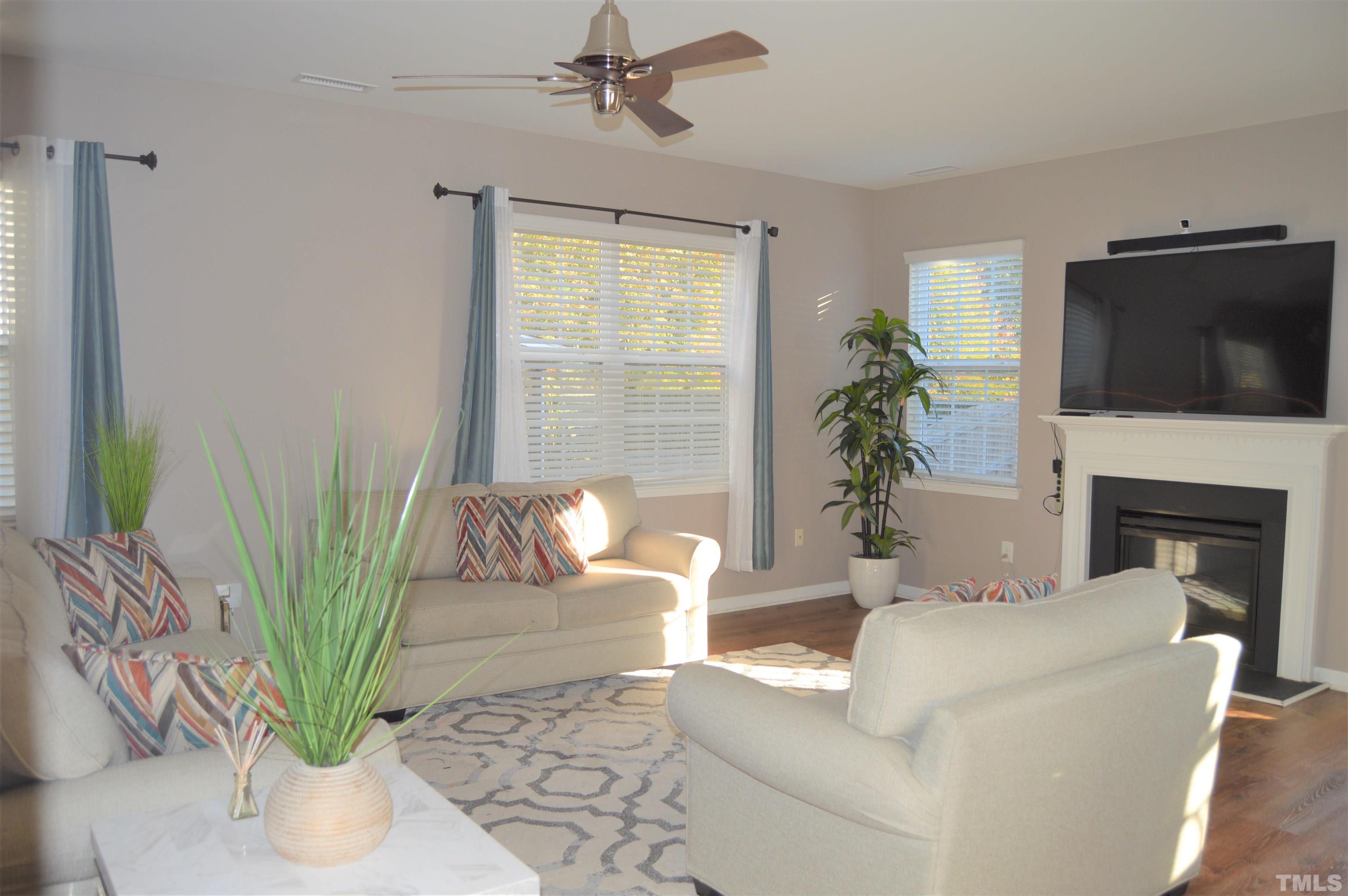 1308 Lombar Street Raleigh, NC 27610 - Photo 6 of 26 a living room with furniture a fireplace and a flat screen tv