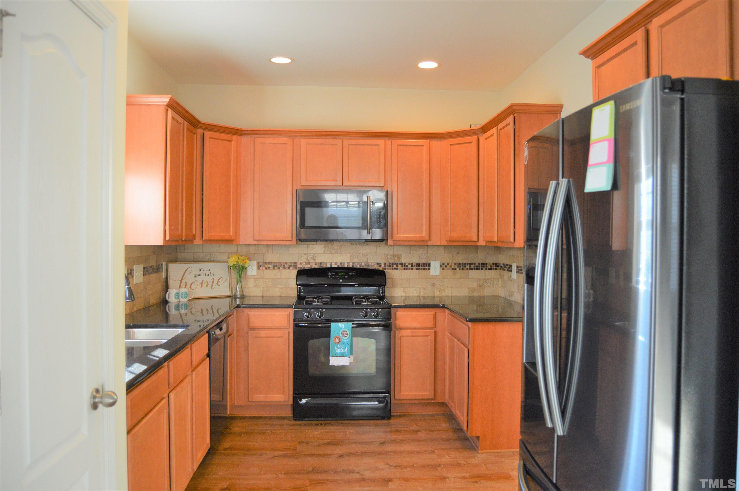 1308 Lombar Street Raleigh, NC 27610 - Photo 9 of 26 a kitchen with stainless steel appliances granite countertop a refrigerator a stove and a sink