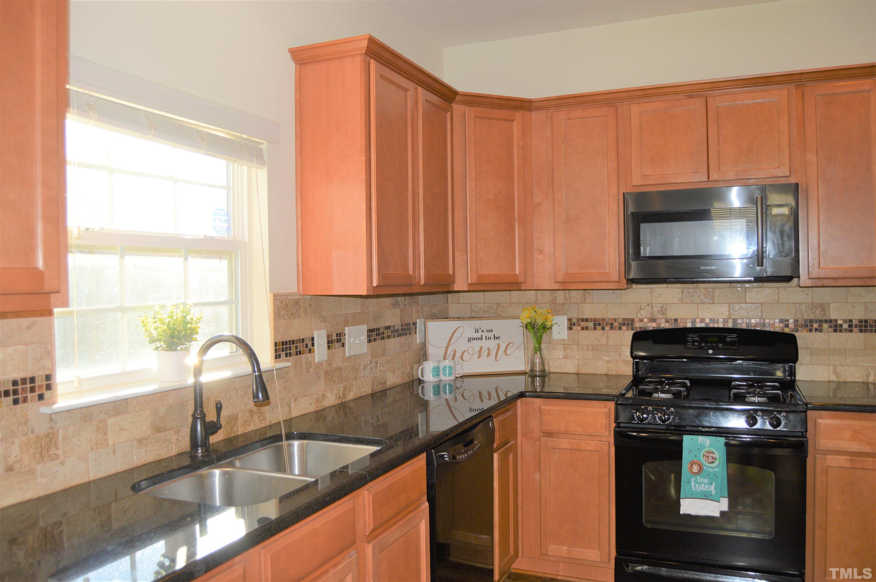 1308 Lombar Street Raleigh, NC 27610 - Photo 10 of 26 a kitchen with granite countertop a sink and a stove top oven with granite countertops