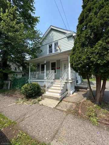 a front view of a house with a yard and potted plants