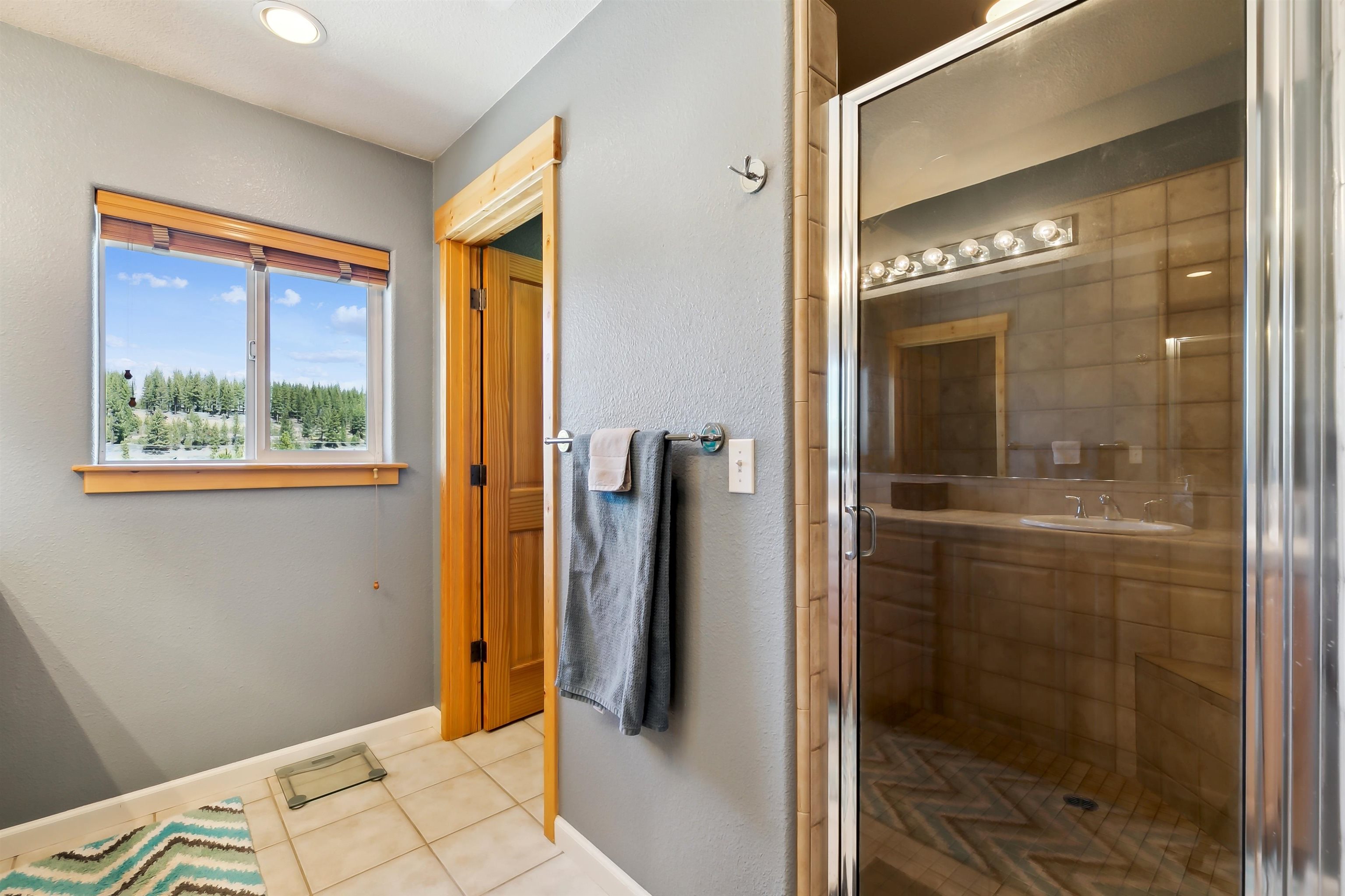 10096 Nicolas Drive, Unit C Truckee, CA 96161 - Photo 16 of 22 a bathroom with a glass shower door and a window