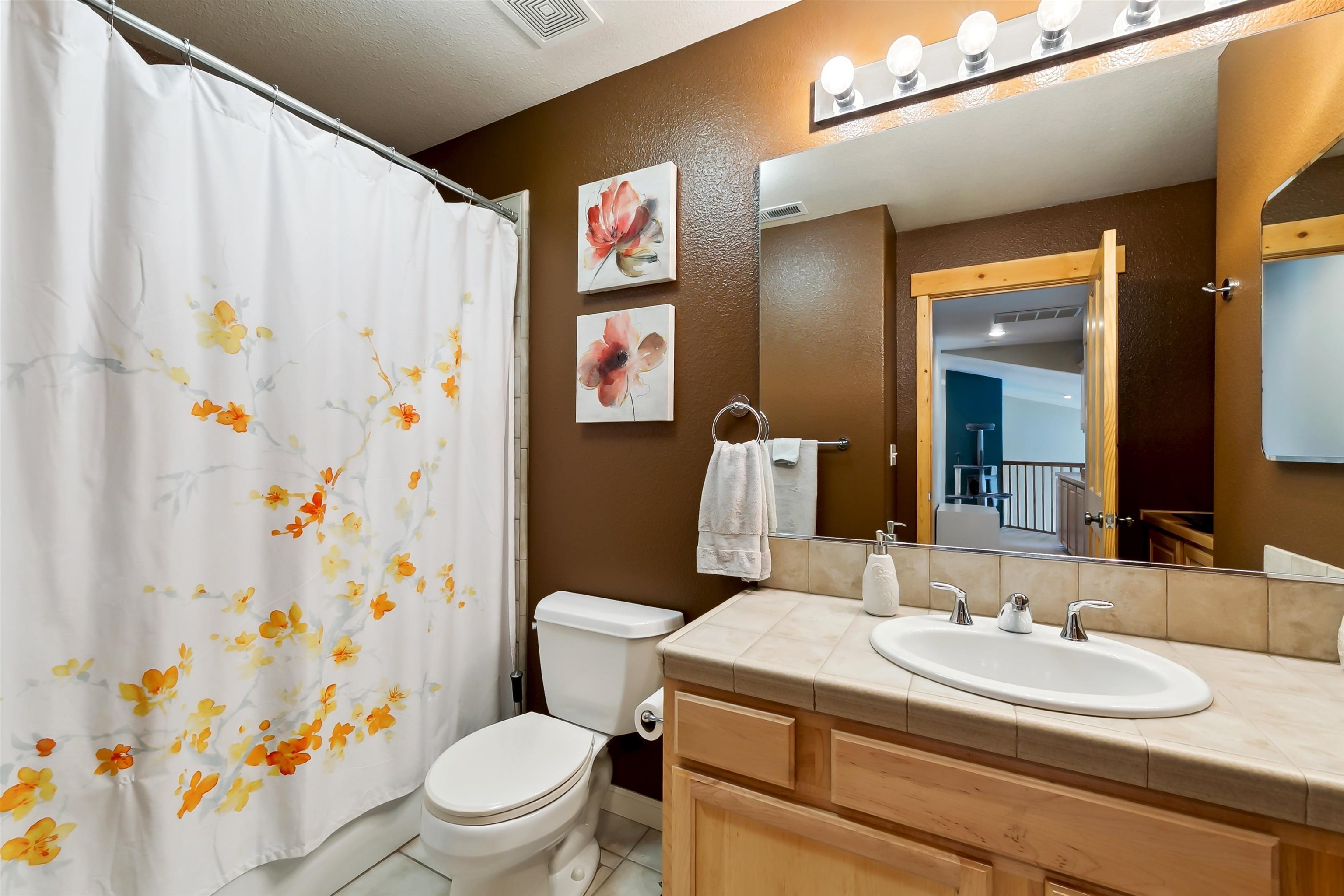 10096 Nicolas Drive, Unit C Truckee, CA 96161 - Photo 18 of 22 a bathroom with a sink a toilet and shower curtain