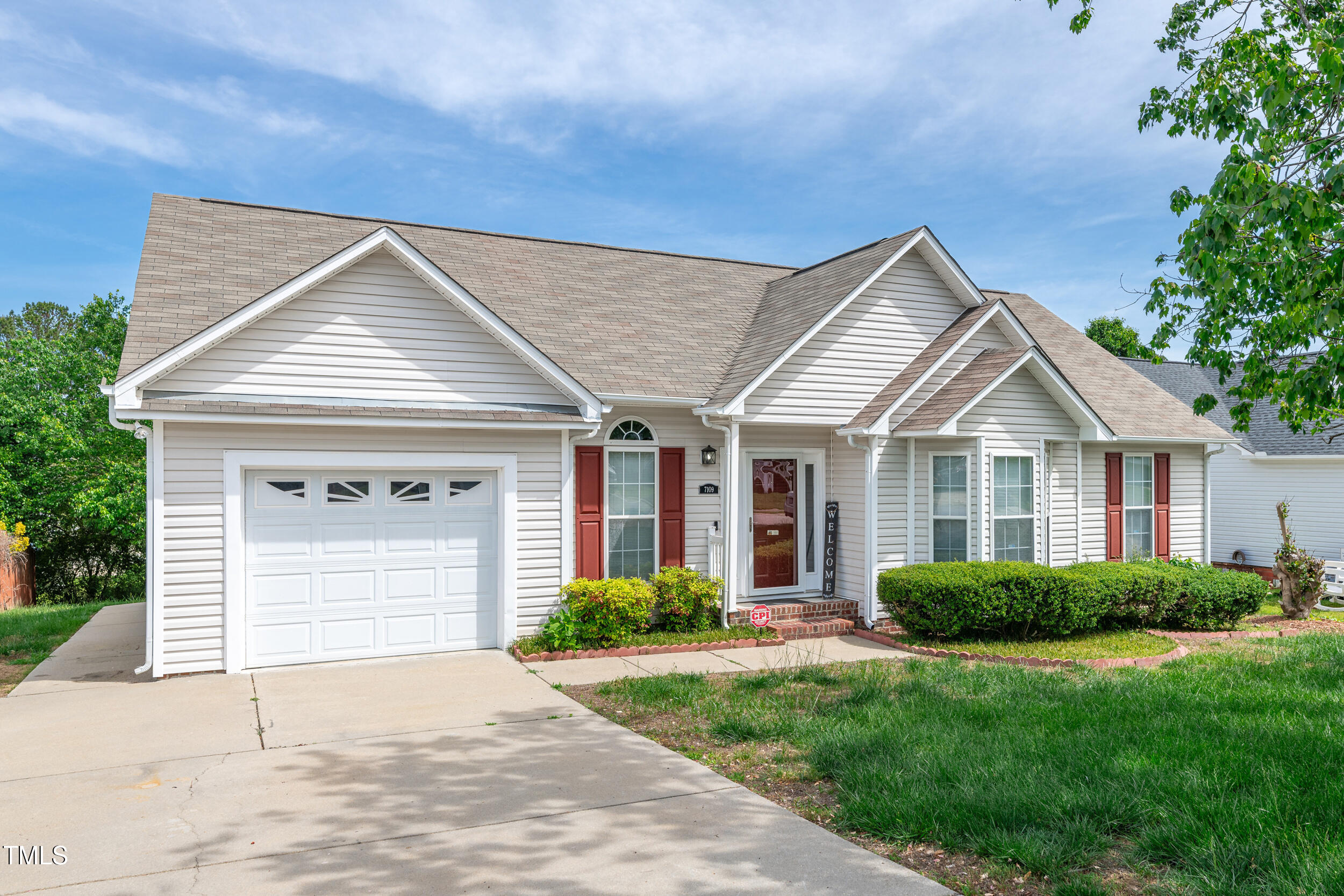 7109 Spanglers Spring Way Raleigh, NC 27610 - Photo 2 of 10 a front view of a house with a garden and plants