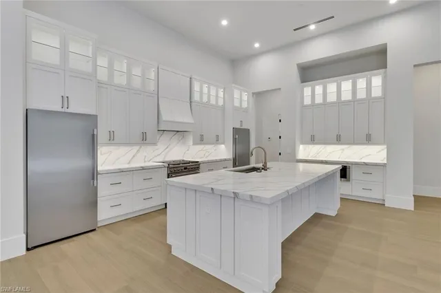 a kitchen with white cabinets appliances and sink