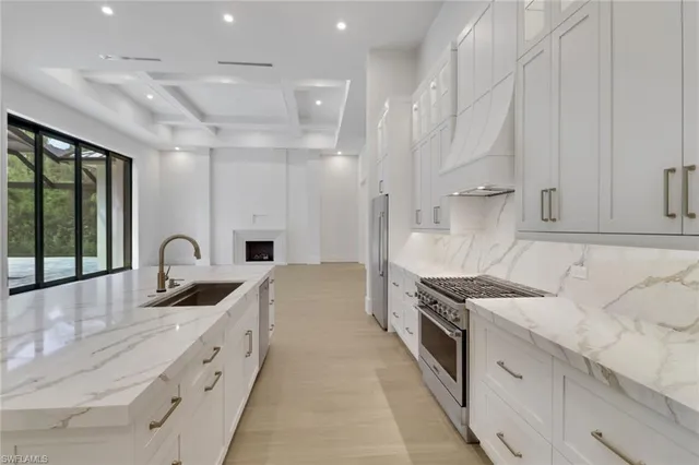 a kitchen with granite countertop a sink stainless steel appliances and cabinets