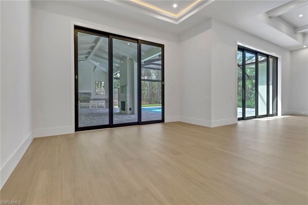 5174 Sycamore Drive Naples, FL 34119 - Photo 16 of 39 an empty room with sliding door and windows