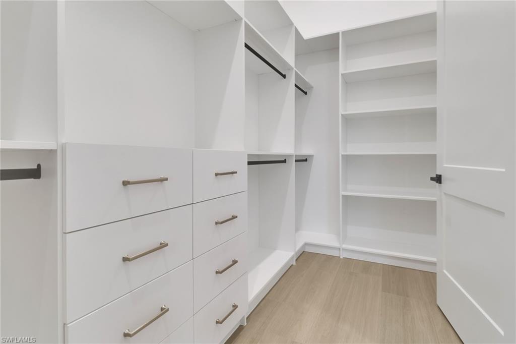 5174 Sycamore Drive Naples, FL 34119 - Photo 19 of 39 a view of walk in closet with empty racks