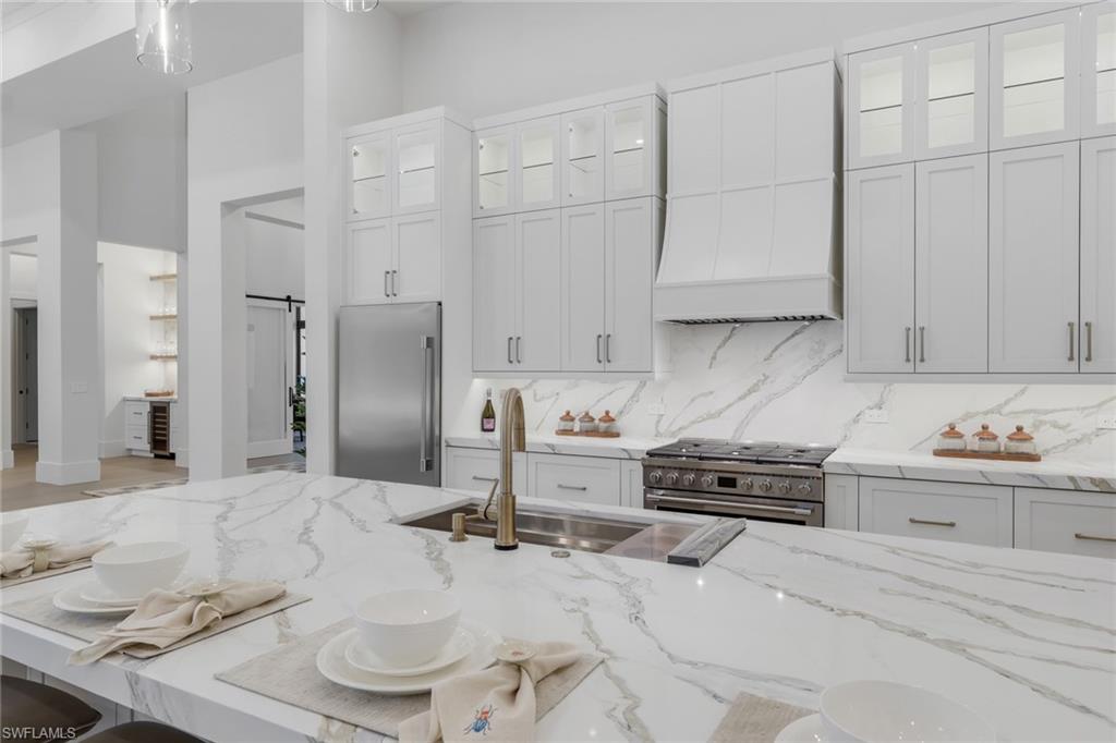 5174 Sycamore Drive Naples, FL 34119 - Photo 20 of 50 a kitchen with granite countertop a sink stove and cabinets