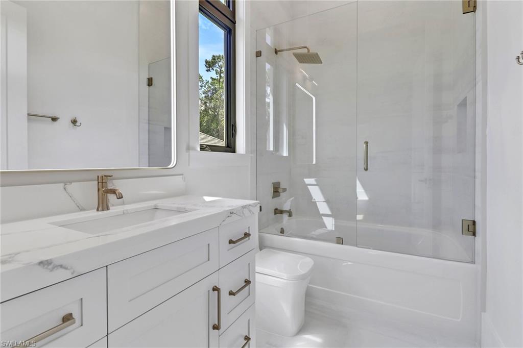 5174 Sycamore Drive Naples, FL 34119 - Photo 25 of 39 a bathroom with a sink a toilet and a bathtub