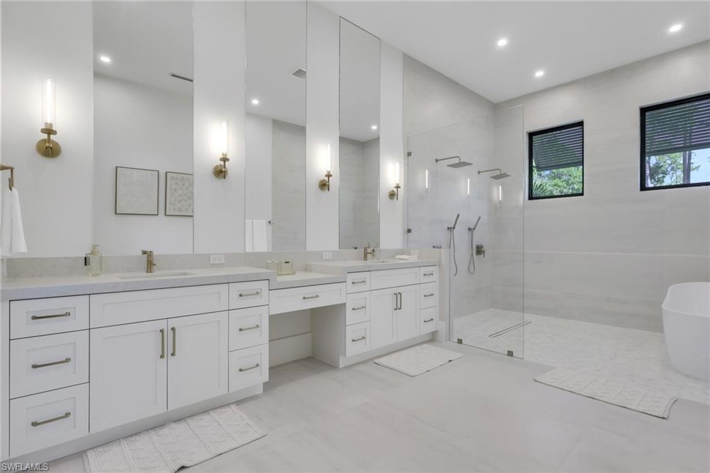 5174 Sycamore Drive Naples, FL 34119 - Photo 26 of 50 a bathroom with double sink and a mirror