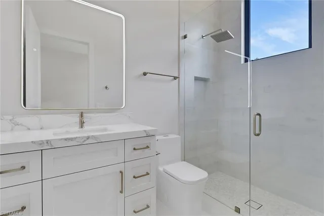 a bathroom with a granite countertop sink toilet and shower