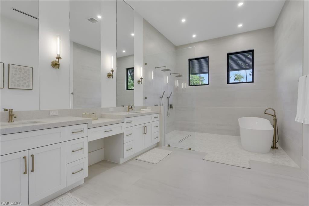 5174 Sycamore Drive Naples, FL 34119 - Photo 27 of 50 a spacious bathroom with a granite countertop sink a toilet a mirror and shower