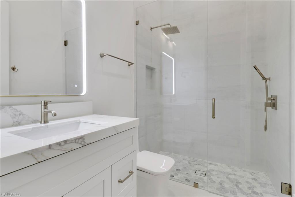 5174 Sycamore Drive Naples, FL 34119 - Photo 29 of 39 a bathroom with a sink toilet and shower