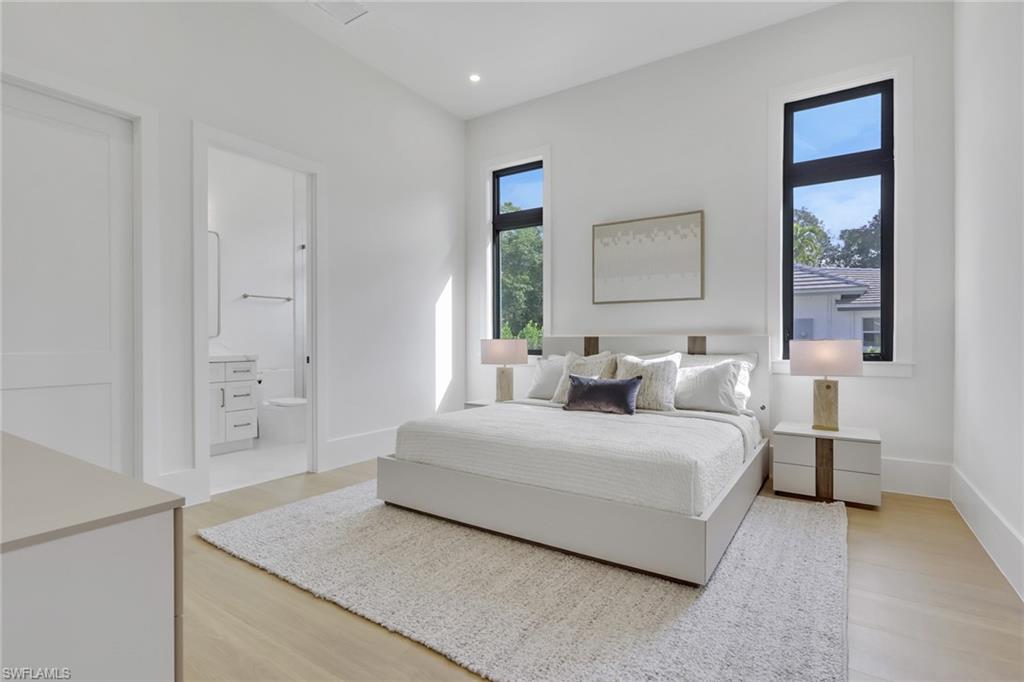 5174 Sycamore Drive Naples, FL 34119 - Photo 31 of 50 a bedroom with a bed and a painting on the wall