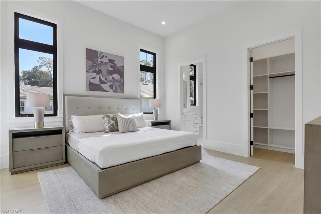 5174 Sycamore Drive Naples, FL 34119 - Photo 33 of 50 a bedroom with a bed and a large window