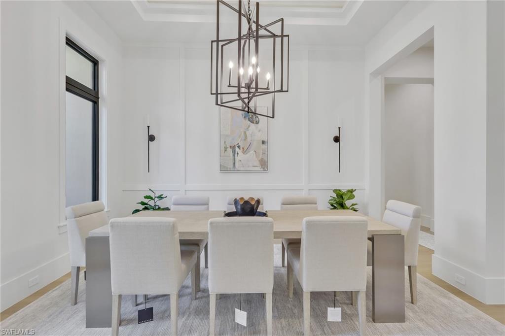 5174 Sycamore Drive Naples, FL 34119 - Photo 4 of 50 a dining room with furniture a chandelier and window
