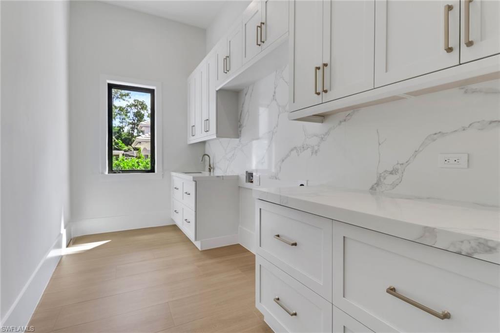 5174 Sycamore Drive Naples, FL 34119 - Photo 43 of 50 a kitchen with cabinets and window