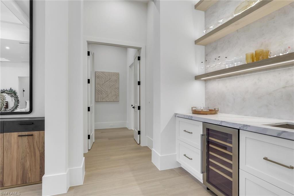 5174 Sycamore Drive Naples, FL 34119 - Photo 5 of 50 a kitchen with cabinets and wooden floor