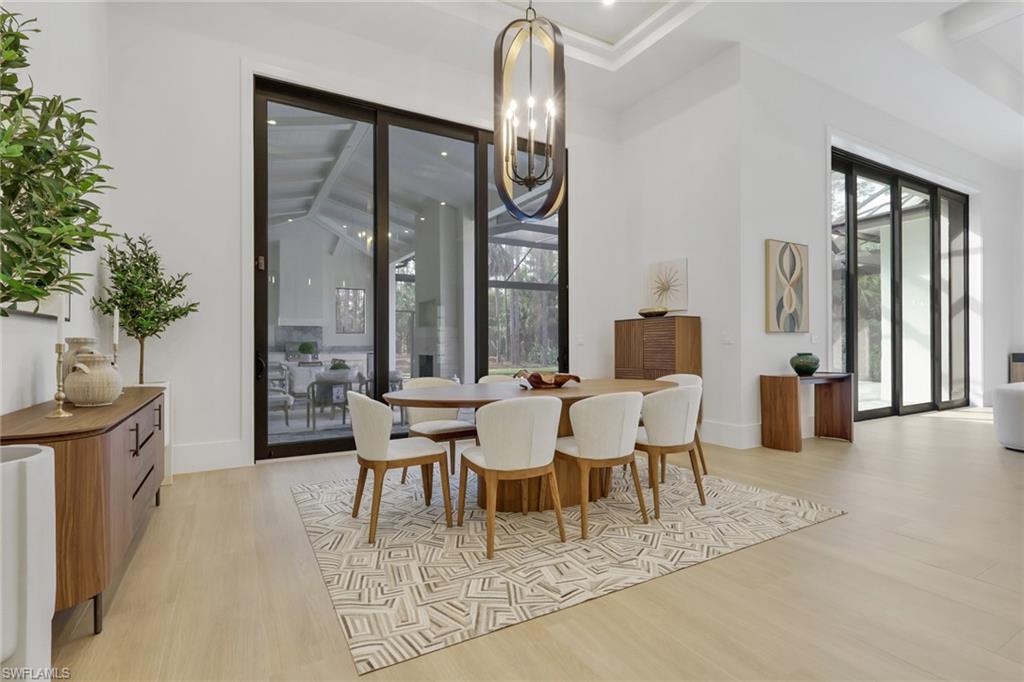 5174 Sycamore Drive Naples, FL 34119 - Photo 8 of 50 a dining room with furniture a chandelier and window