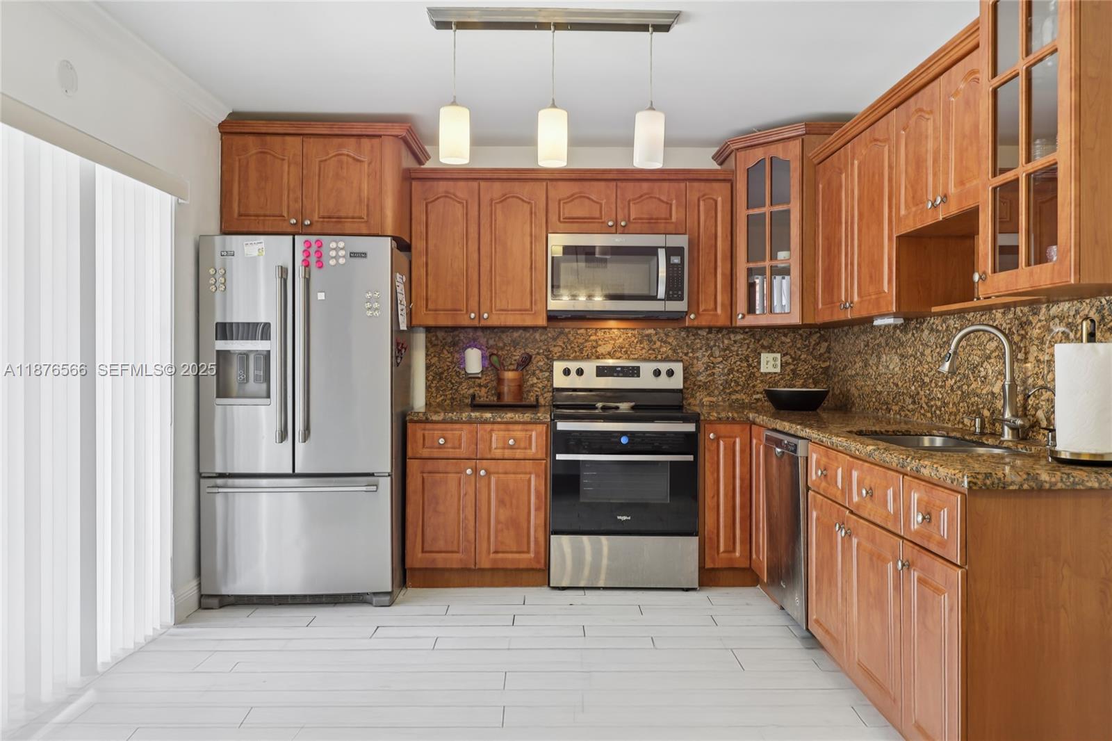 751 Southwest 120th Way Davie, FL 33325 - Photo 13 of 43 a kitchen with stainless steel appliances granite countertop a refrigerator stove and a sink