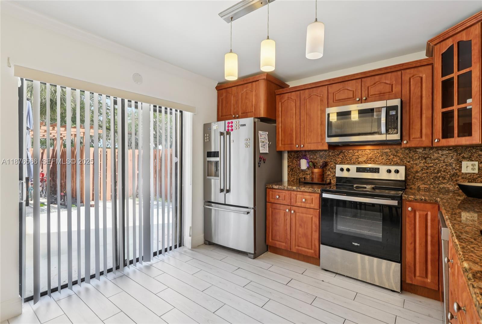 751 Southwest 120th Way Davie, FL 33325 - Photo 14 of 43 a kitchen with stainless steel appliances granite countertop a refrigerator and a stove top oven