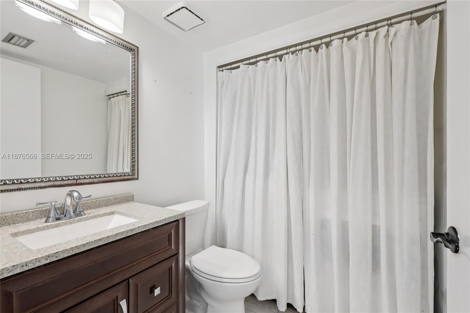 751 Southwest 120th Way Davie, FL 33325 - Photo 16 of 43 a bathroom with a granite countertop sink toilet and a mirror