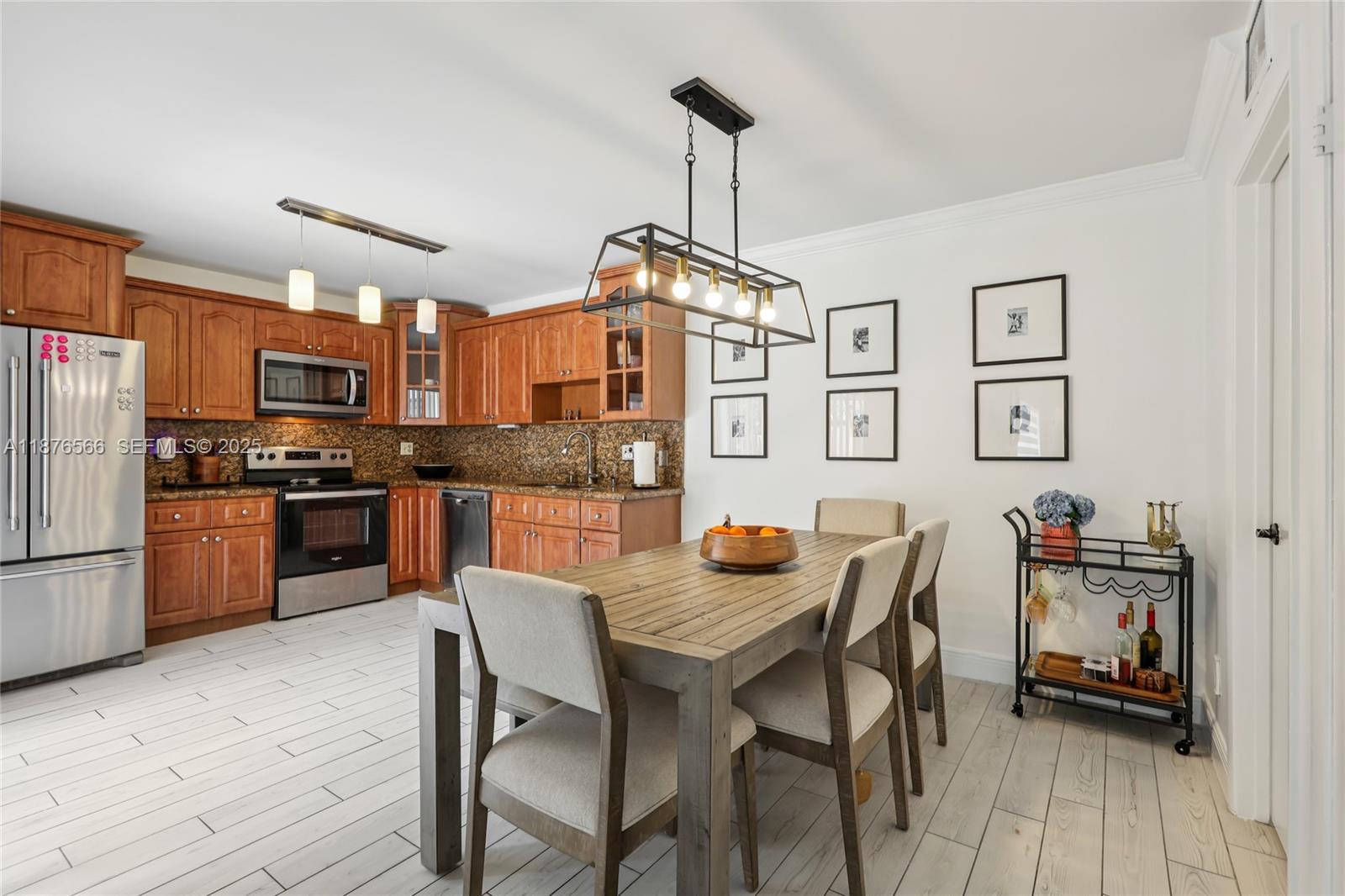 751 Southwest 120th Way Davie, FL 33325 - Photo 9 of 43 a kitchen with granite countertop a table chairs stainless steel appliances and cabinets