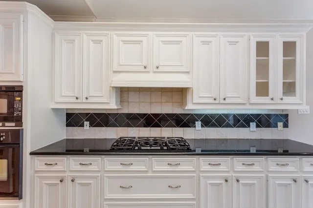 a kitchen with white cabinets and appliances