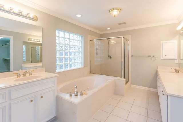 a spacious bathroom with a tub sink and mirror