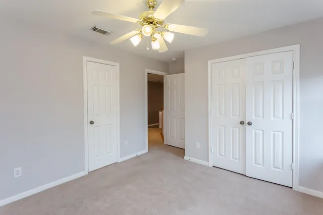a view of a room with a ceiling fan and a ceiling fan