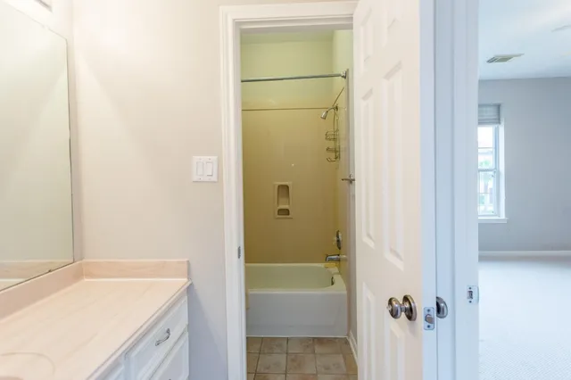 a bathroom with a tub shower and a sink