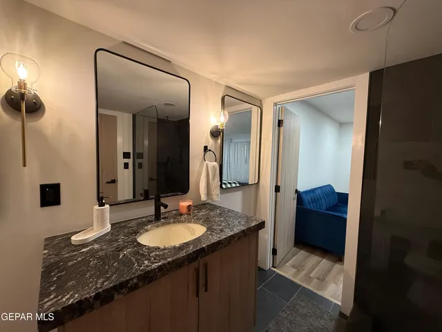 a bathroom with a granite countertop sink and a mirror