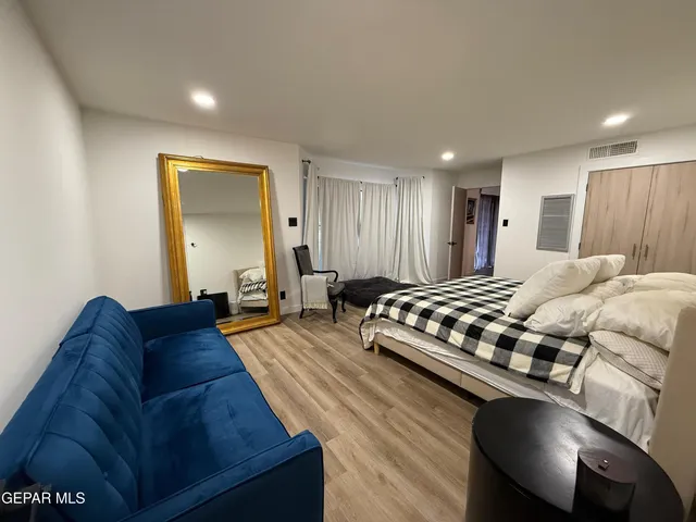 a spacious bedroom with a bed and a couch