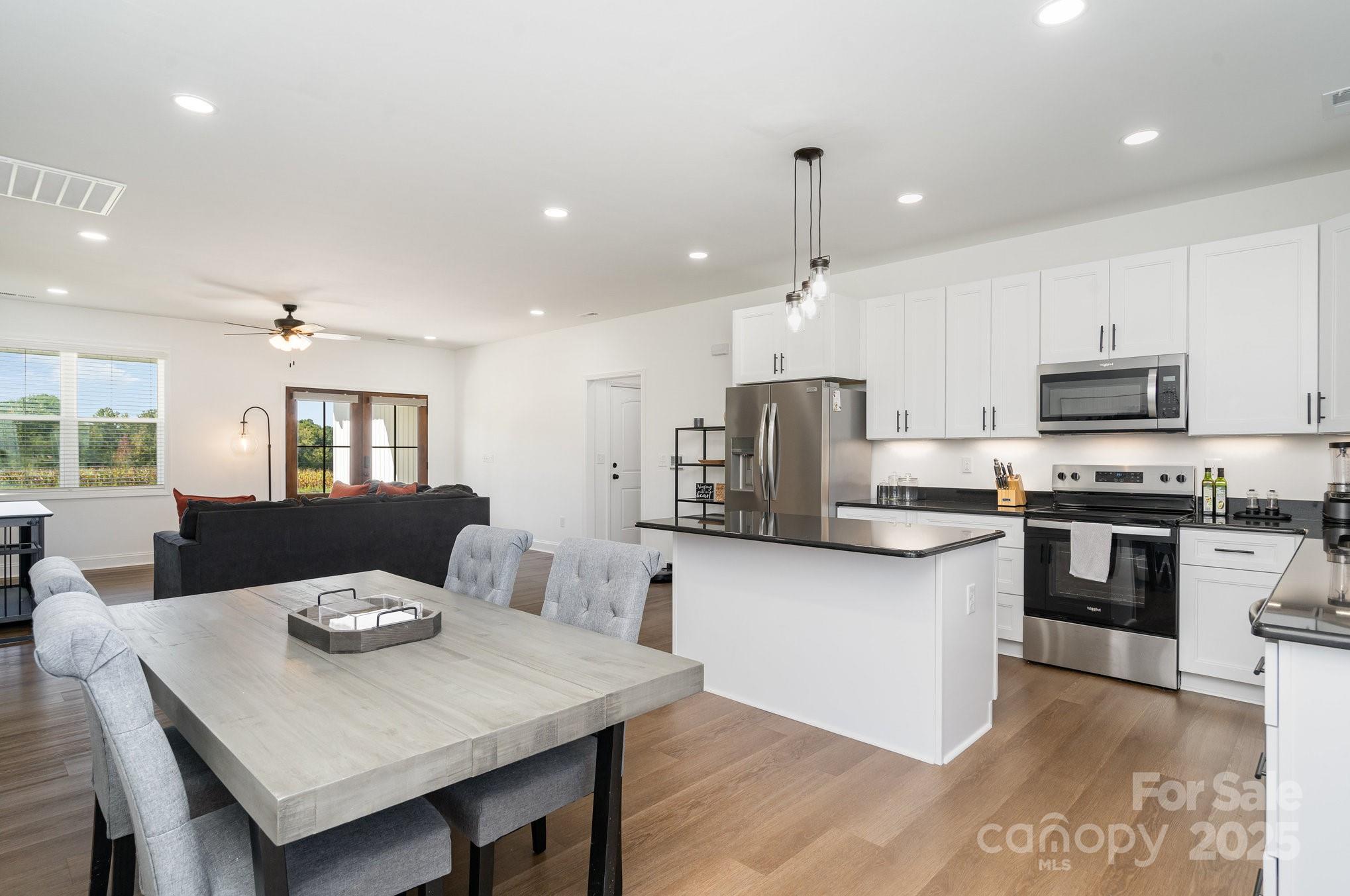 125 St Peters Church Road Gold Hill, NC 28071 - Photo 11 of 33 a kitchen with stainless steel appliances kitchen island granite countertop a stove a sink a dining table and chairs