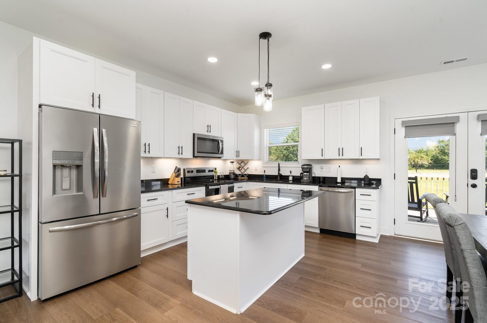 125 St Peters Church Road Gold Hill, NC 28071 - Photo 12 of 33 a kitchen with white cabinets stainless steel appliances and wooden floor