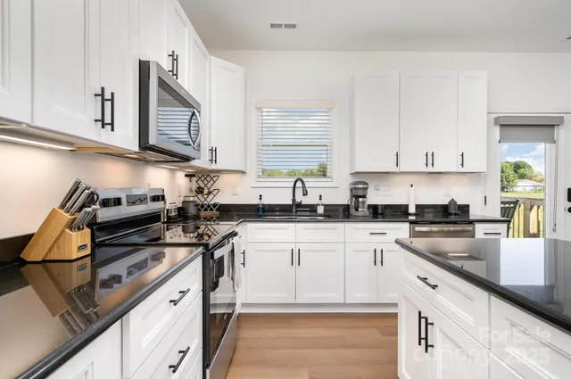 a kitchen with cabinets appliances a sink and a counter top space