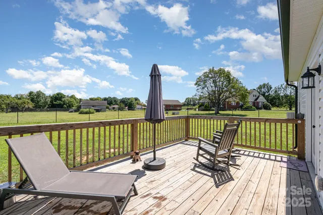 a view of a balcony with wooden floor and fence
