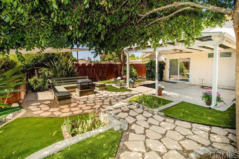 a view of a patio with table and chairs potted plants and large tree