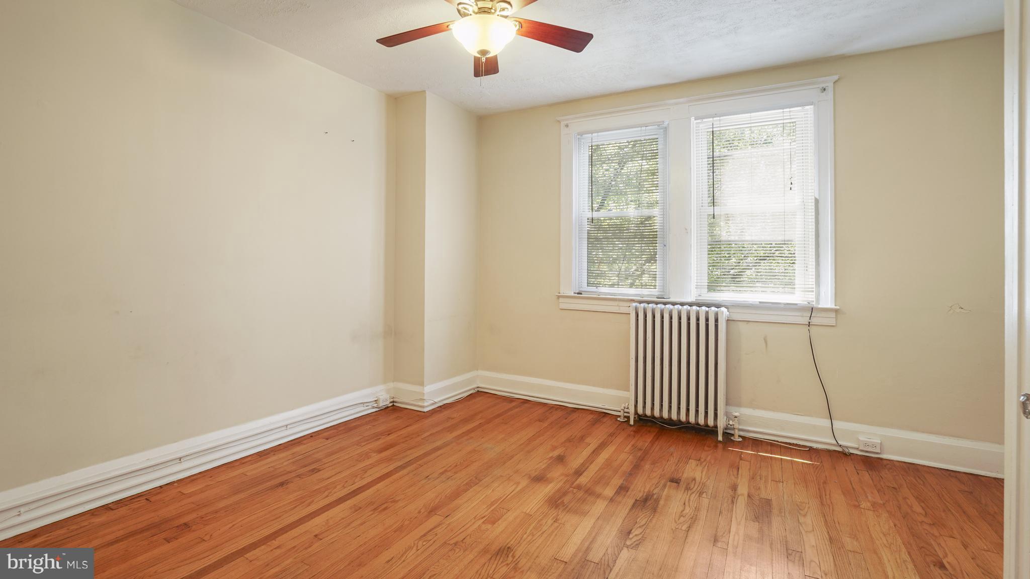 6214 Frederick Road Catonsville, MD 21228 - Photo 4 of 10 an empty room with wooden floor and windows