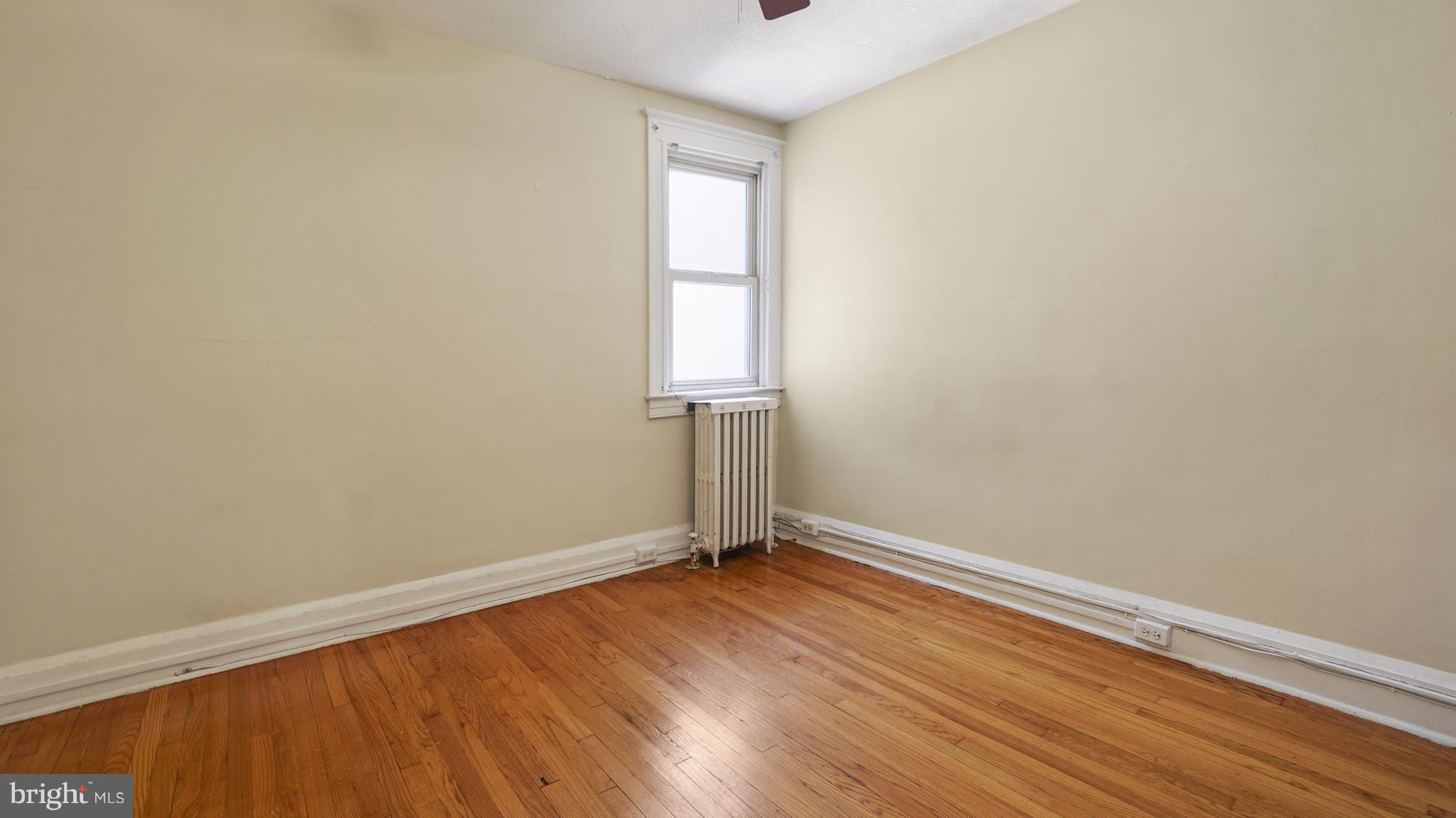 6214 Frederick Road Catonsville, MD 21228 - Photo 5 of 10 an empty room with wooden floor and windows