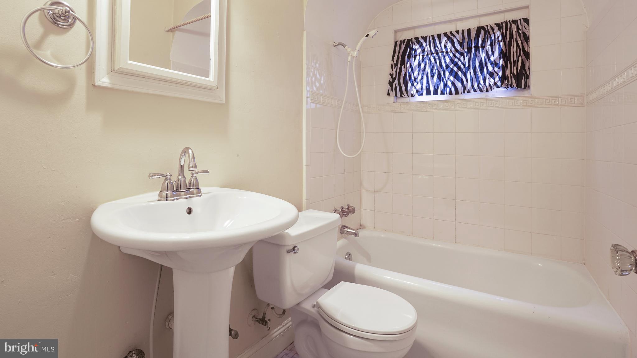 6214 Frederick Road Catonsville, MD 21228 - Photo 7 of 10 a bathroom with a sink a toilet and shower