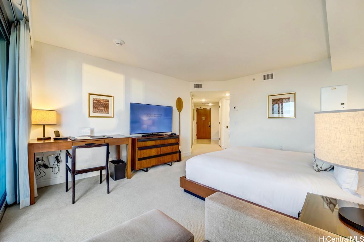 223 Saratoga Road, Unit 2006 Honolulu, HI 96815 - Photo 12 of 15 a bedroom with a bed and a desk in it